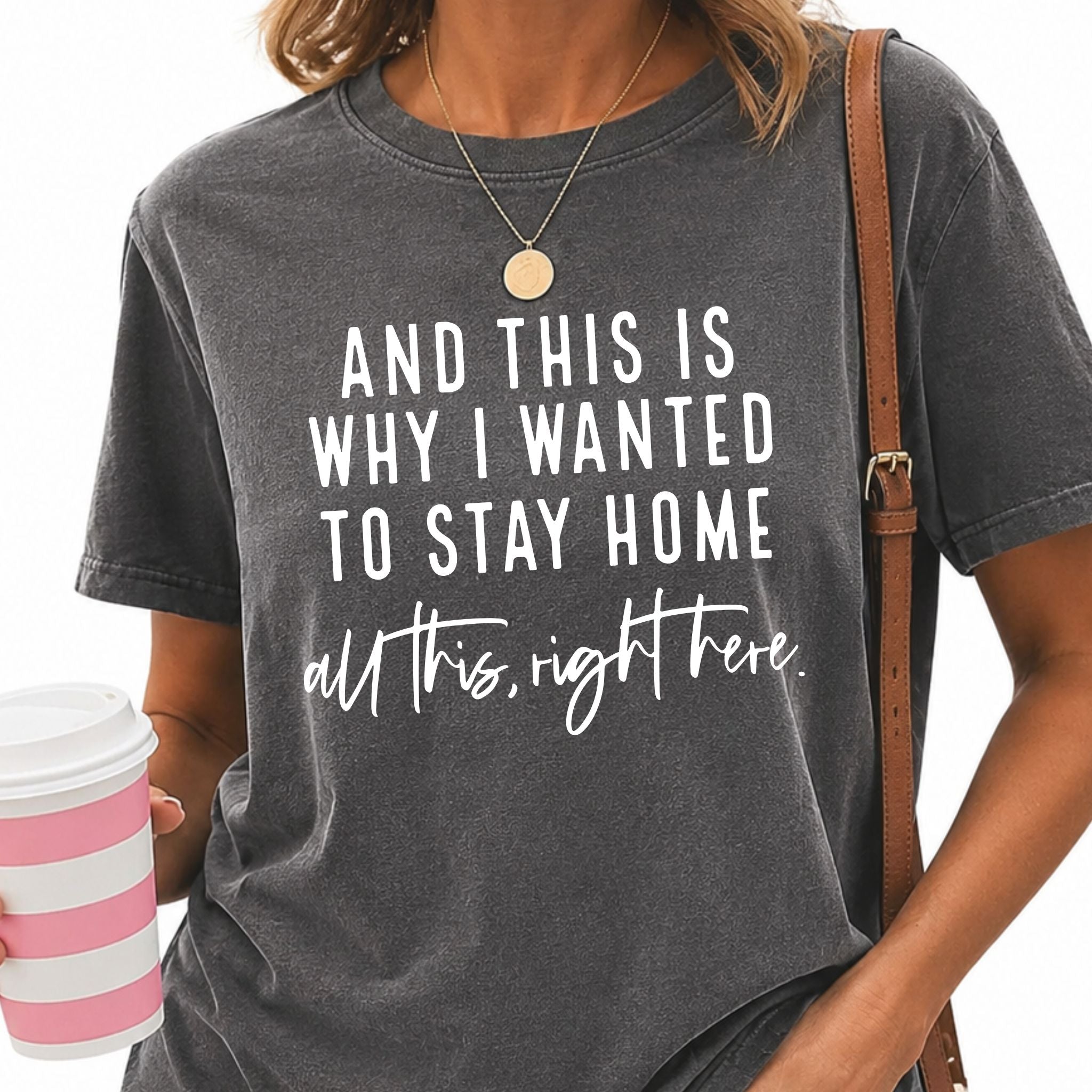 40 + woman wearing a gray t-shirt with a humorous quote, holding a pink and white striped cup.