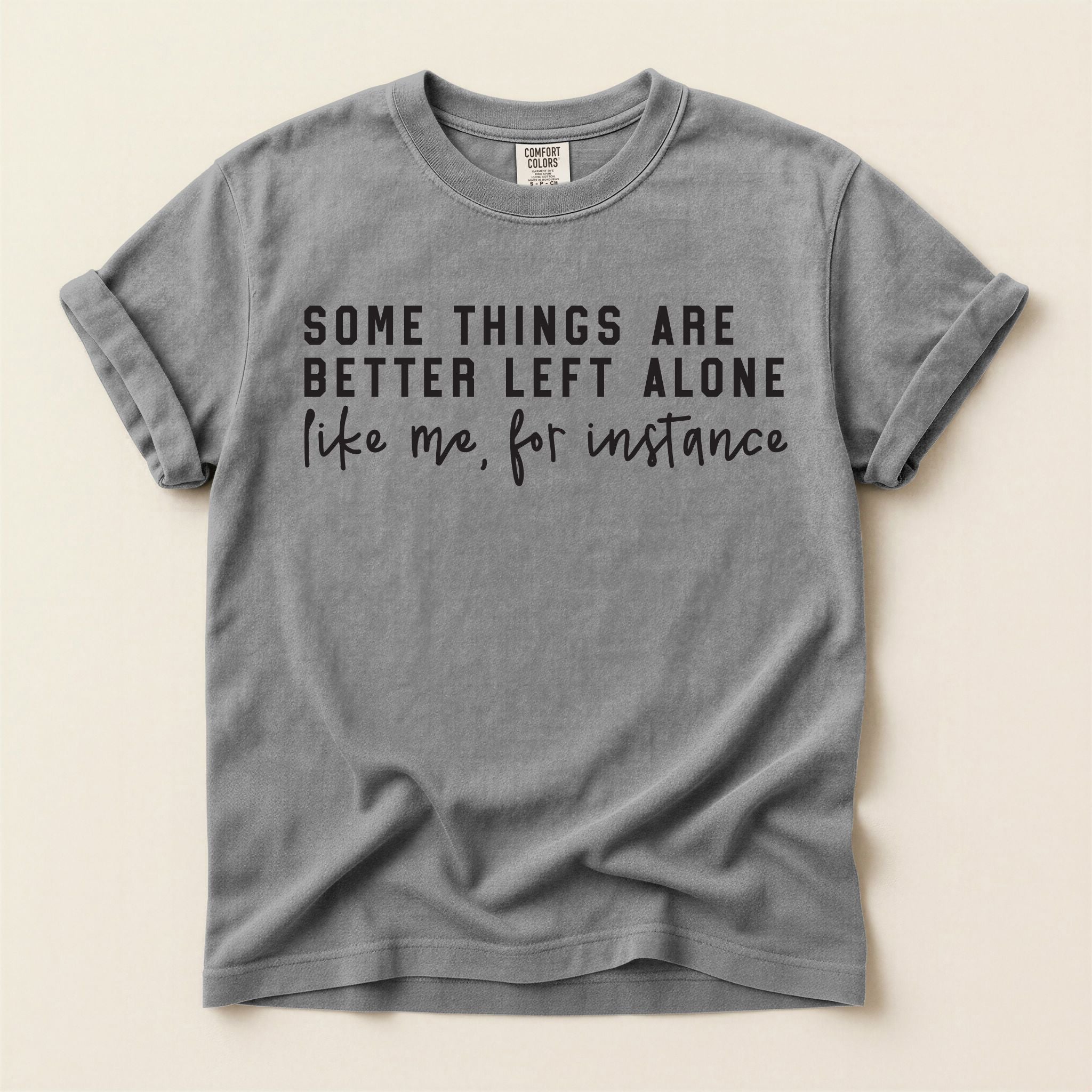 Gray t-shirt with humorous text on a beige background