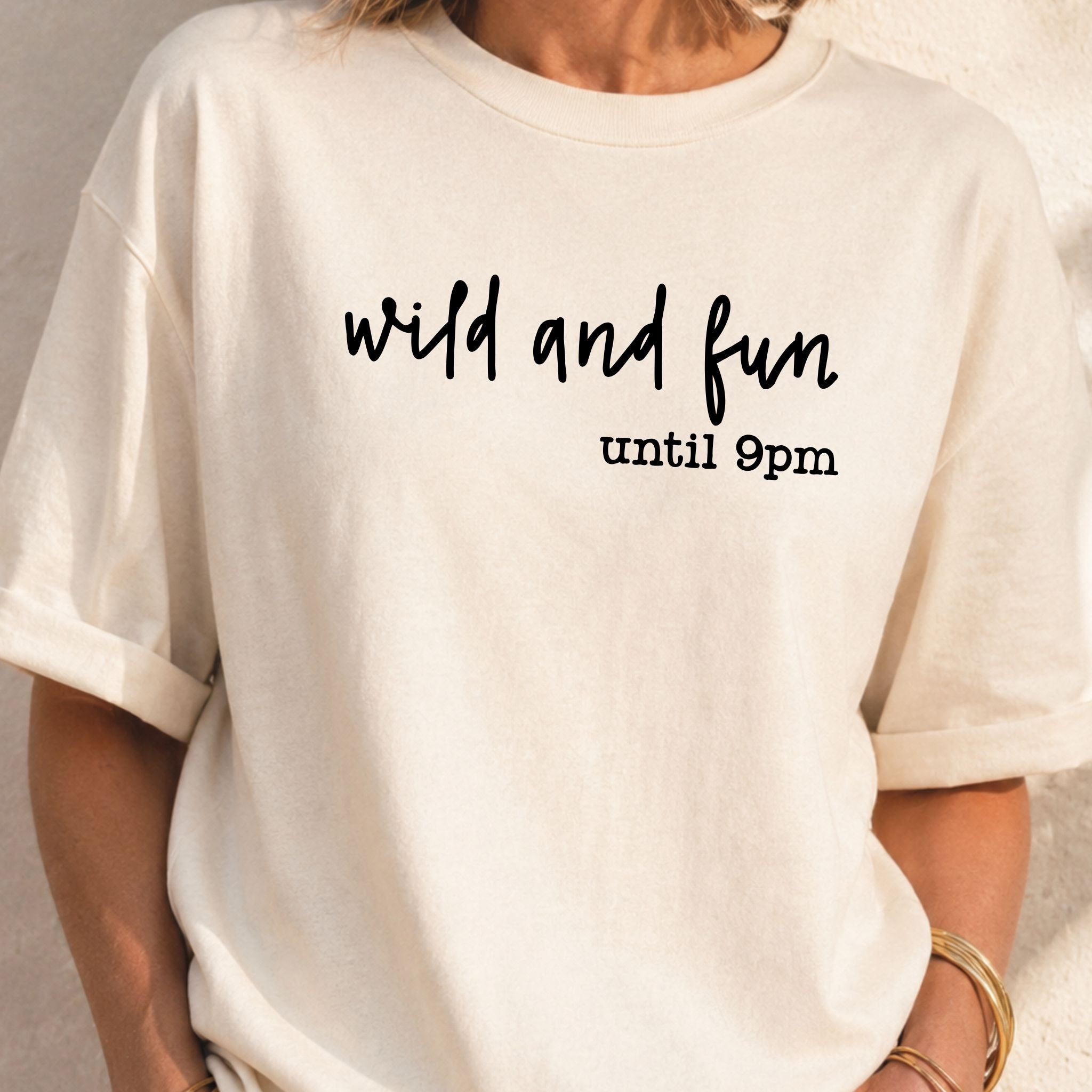 Beige t-shirt with 'wild and fun until 9pm' text on a neutral background