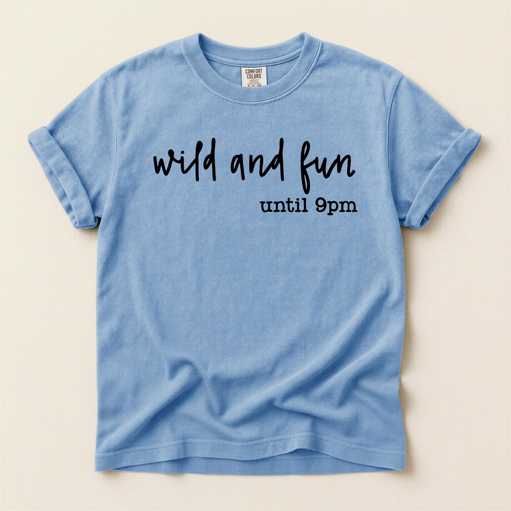 Blue t-shirt with 'wild and fun until 9pm' text on a beige background